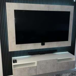 Newly built media wall with white cabinets mounted on a dark wooden paneling in Northampton